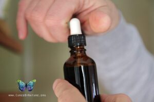 A person holding a dropper bottle of cannabis beauty products._SCALED