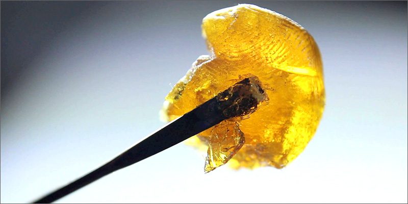 A piece of yellow CBD wax on a toothpick.